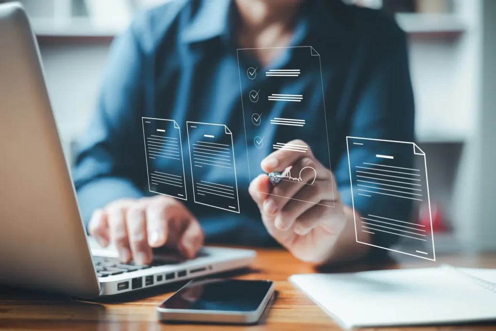 Person nutzt Laptop zur digitalen Dokumentenverwaltung mit virtuellen Formularen und Checklisten. Das Bild symbolisiert moderne Büroarbeit, papierloses Arbeiten und elektronische Signaturprozesse in der Cloud.
